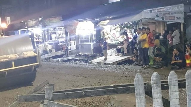 Alat berat meratakan material di Jl Antang Raya, Sabtu (8/10) malam. Warga ikut menonton pengerjaan jalan ini. [Dok. HN)