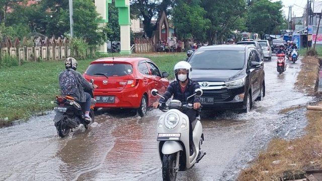 Pengendara melintasi genangan di Jl Bontotanganga, Selasa (29/11). 