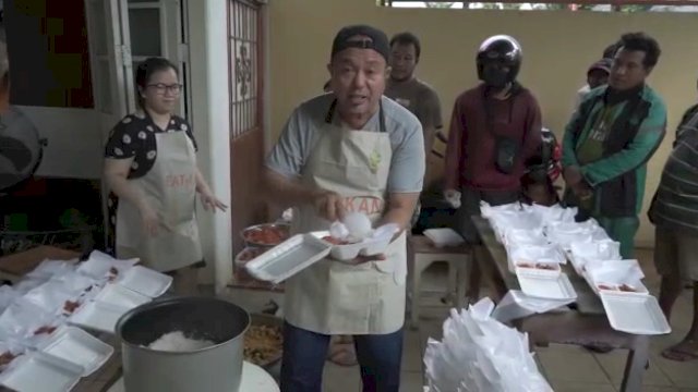 Nasran Mone menyiapkan makanan warung jumat berkah. 