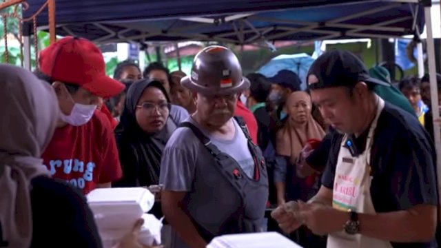 Nasran Mone (pakai topi) meladeni warga di Warung 2000, Jumat (30/12). Ist