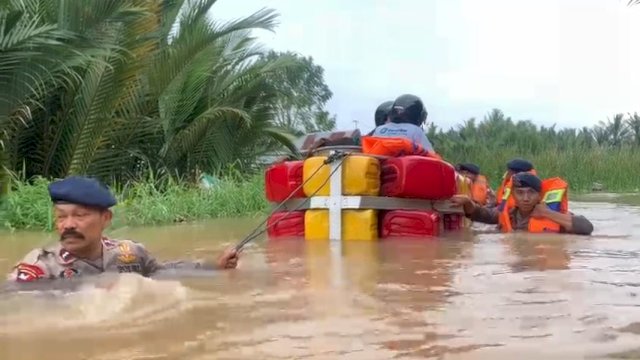 Aksi Brimob Polda Sulsel melakukan evakuasi korban banjir, Minggu (25/12). 
