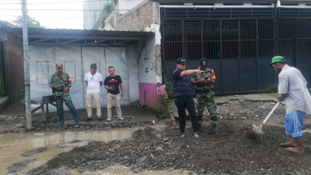 Taufik Surullah (rompi hitam) turun memantau penimbunan jalan. 