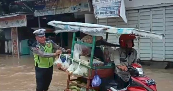 FOTO: Polisi Bantu Dorong Motor Pedagang Sayur Ditengah Genangan Air