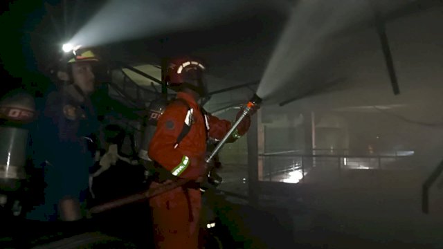 Personil Damkar Makassar memadamkan api di Pasar Terong Makassar, Minggu (5/2). Dok. OS