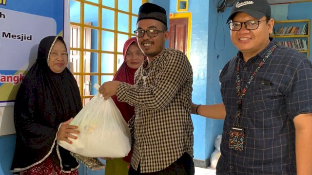 H.Erwin, SH, MH Kepala desa Bontomanai saat memberikan bantuan kepada penerima manfaat. 