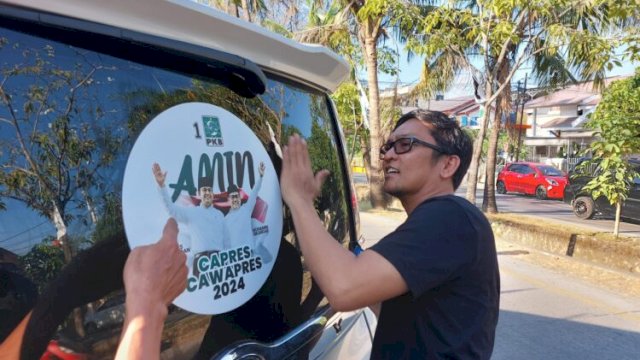 Ketua DPC PKB Makassar, Fauzi Andi Wawo memasang langsung stiker AMIN di mobil pribadi Deng Ical, Sabtu (23/9). 