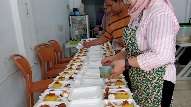 Personel Warkop D'K10 sedang mempersiapkan nasi kotak untuk dibagikan dalam Jumat Berkah. Foto: dok HN