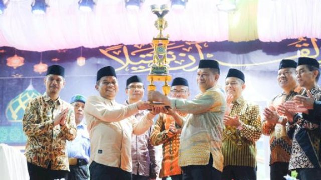 PJ Bupati Jeneponto Junaedi Bakri saat menyerahkan piala kepada Kafilah Kecamatan Tamalatea Foto: dok Humas Kominfo Jeneponto