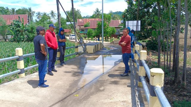 Lembaga besar aliansi mahasiswa dan pemuda saat mengunjungi jembatan gantung Bontomanai yang rusak bersama Rahim PPK Jembatan Gantung yang mengenakan switer merah pakai topi dan Abrar Selaku Kontraktor yang mengenakan baju merah tidak pakai topi (22/3/2024). Foto: HN/Aswin