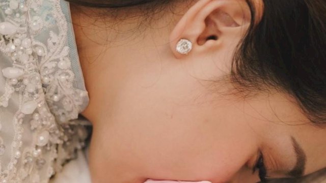 Nagita Slavina mencium kepala Lyli yang diduga anak adopsinya. (Foto: Instagram @raffinagita1717)