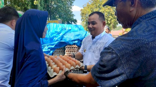 Pj. Bupati Sinjai, T.R Fasul Falah memberikan telur kepada warga yang membutuhkan usai memborong Telur Ayam di Pasar Sentral Sinjai, Jumat (5/4) siang ||Foto:Humas