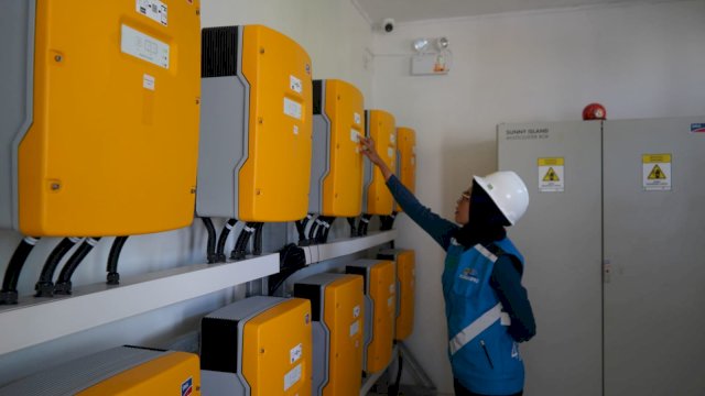 Petugas PLN tengah mengecek inverter baterai PLTS Tanamalala. (Fptp" dok PLN)
