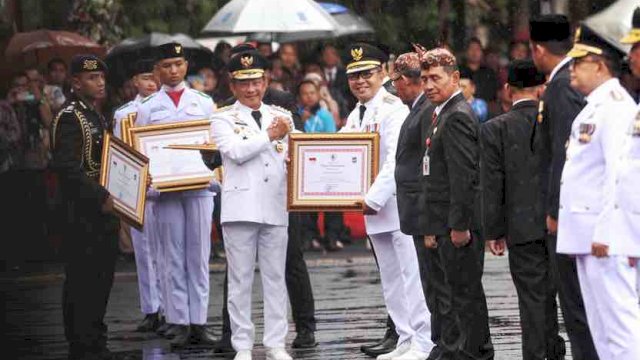 Menteri Dalam Negeri (Mendagri) Tito Karnavian menyerahkan penghargaan kepada Wali Kota Makassar Moh Ramdhan Pomanto pada Puncak Peringatan Hari Otonomi Daerah (OTDA) XXVII, di Halaman Balai Kota Surabaya, Kamis (25/4/2024).