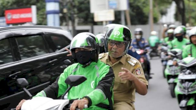 Wali Kota Makassar Moh Ramdhan Pomanto saat ikut menggunakan ojek online pada Ojol Day. Foto: dok