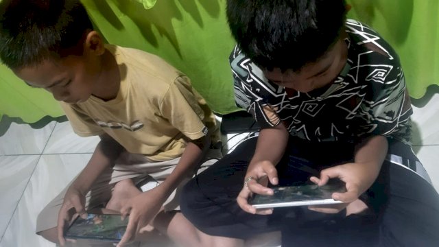 Abdul Gatfan (Kaos Kuning), Muh. Abid Fauzan (Kaos Merah) sedang bermain game. (Foto: Gita/HN)