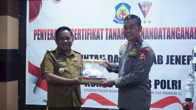 Pj Bupati Sinjai Junaedi Bakri saat penyerahan sertifikat tanah. Foto: ist
