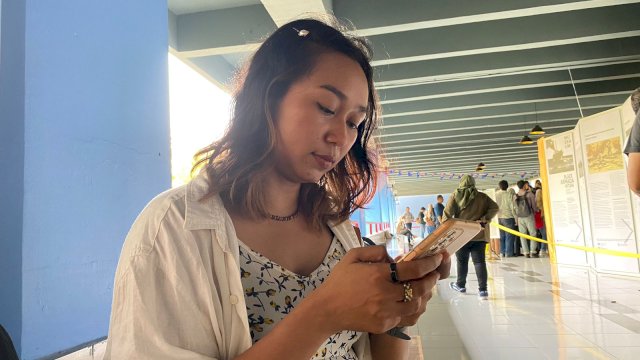 Reni sedang menyelesaikan tugasnya sebagai jurnalis. (Foto: Gita/HN)