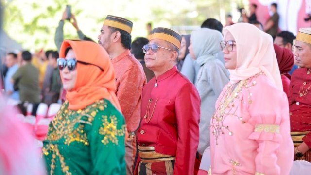 Dirut Perumda Parkir Makassar Raya (kanan) palaian adat di HUT Makassar. 