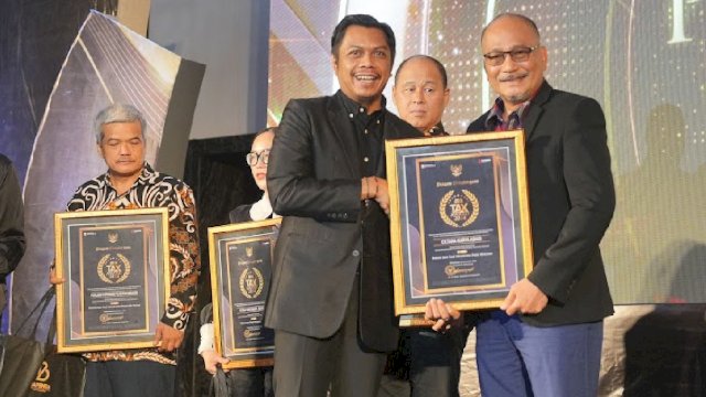 Kepala Bapenda Kota Makassar, Firman Hamid Pagarra, menyerahkan penghargaan kepada salah satu wajib pajak berprestasi pada acara Tax Award 2024 di Phinisi Ballroom Hotel Claro, Jumat (06/12/2024). 