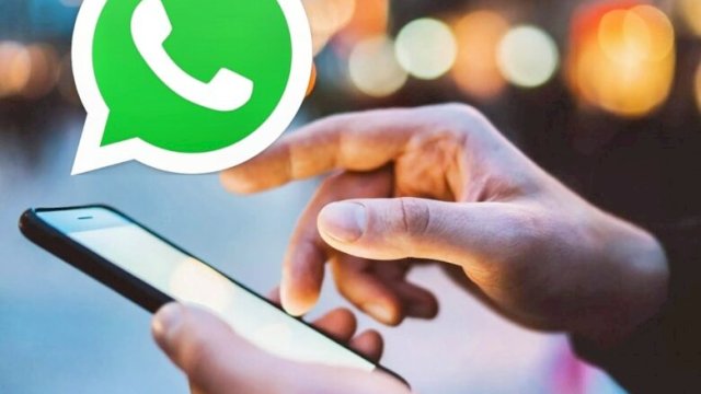 Ilustrasi tangan memegang ponsel dengan notifikasi pesan WhatsApp di layar ||net