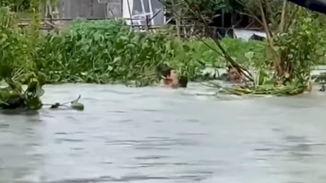 Aksi seorang pria menyelamatkan bocah perempuan yang terseret arus banjir di BTP Blok AC, Kecamatan Tamalanrea. Foto: tangkapan layar