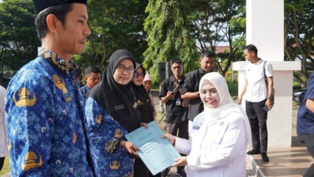 Bupati Sinjai Hj. Ratnawati Arif menyerahkan SK perpanjangan masa kerja PPPK secara simbolis pada apel gabungan dan Halal Bihalal di halaman Kantor Bupati Sinjai || handover 