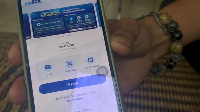 Mustaqim, Ketua Pengurus Harian Aliansi Masyarakat Adat Nusantara (PH AMAN) Gowa saat memperlihatkan m-banking yang sudah sering digunakannya bertransaksi digital. (Foto: Gita/HN)