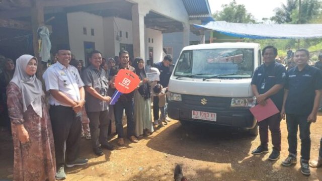 Jumali berpose di samping mobil Suzuki Pickup hadiah dari BRI, disaksikan warga Dusun Datara ||handover_docbrisungguminasa