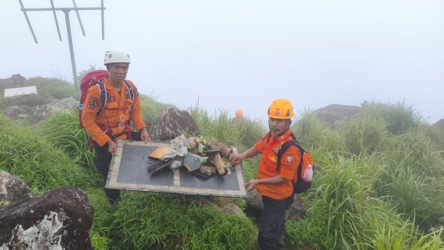 Tim menunjukan serpihan pesawat ATR yang ditemukan di pegunungan Bulusaraung, Pangkep, Minggu (18/1). (Dok. BPBD Makassar).