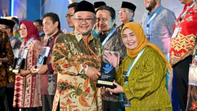Bupati Sinjai (kanan) menerima penghargaan dari Menteri. (Dok. Humas)