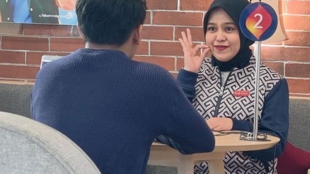 Karyawan Telkomsel saat berkomunikasi dengan teman tuli. (Dok. Telkomsel)
