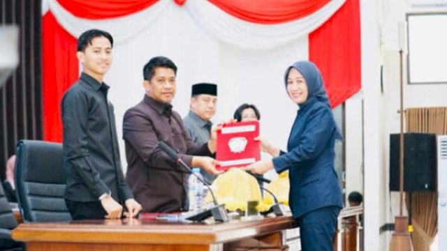 Anggota Fraksi Gerindra DPRD Gowa, Dian Purnamasari menyerahkan dokumen pandangan fraksi kepada pimpinan dewan dalam rapat paripurna dewan pada Senin (25/05/2026). || (ho_yos_harian.news)