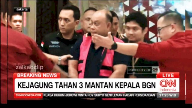 Mantan Kepala BGN Dadan Hindayana keluar dari Gedung Jampidsus Kejagung RI, Rabu (3/6/2026). Ia tampak mengenakan rompi tahanan merah muda sambil digiring petugas ke kendaraan tahanan. (tangkaplayar_cnnindonesia)