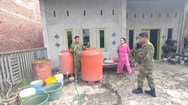 Personel Koramil 1419-01/Maiwa mendistribusikan air bersih kepada warga yang terdampak kemarau di Kecamatan Maiwa, Enrekang. ||(foto handover_harian.news)