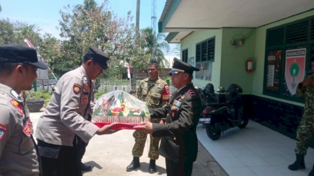 Pj Danramil 1419-01/Maiwa Letda Inf Amrullah menerima nasi tumpeng dari jajaran Polsek Maiwa dalam momentum HUT ke-81 TNI ||(Kredit foto:Koramil 1419-01) 