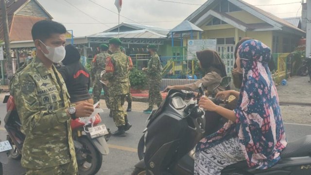 Personel Koramil 1419-01/Maiwa membagikan masker kepada warga di jalan poros Enrekang&ndash;Sidrap || (Kredit foto:Koramil 1419-01) 