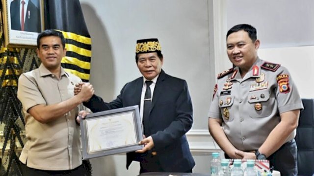 Gubernur Kaltara, Zainal Arifin Paliwang menyerahkan penghargaan kepada jajaran Ditreskrimsus Polda Sulsel atas pengungkapan kasus dugaan penipuan online yang mencatut identitasnya ||(Kredit foto:handover_igadiwia@harian.news) 