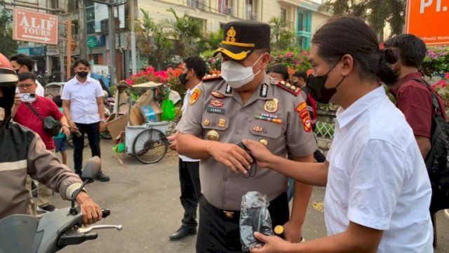 Kapolres Pelabuhan Makassar AKBP Kaisar Reman Sambo membagikan masker gratis kepada pengendara sepeda motor dan masyarakat di tengah kondisi udara Makassar yang terdampak kabut asap. Harian.News/HO-Polres Pelabuhan Makassar&nbsp;