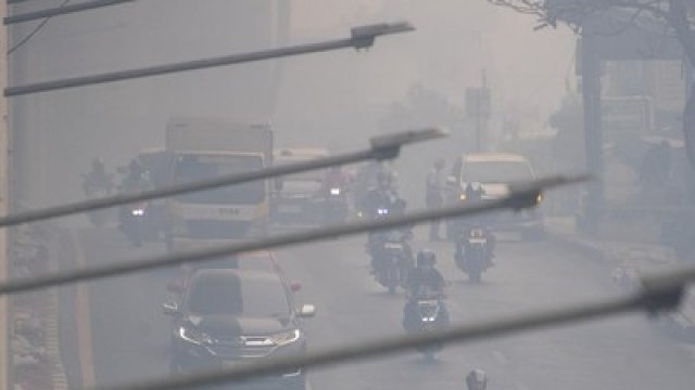 Sejumlah pengendara melintas di Jalan Kol H Burlian yang diselimuti kabut asap di Palembang, Sumatera Selatan, Selasa (20/10/2026). (ANTARA FOTO/NOVA WAHYUDI)